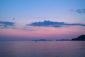 purple-pink sky is reflected in the sea