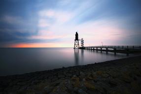 photo of a lighthouse on the shore of the North Sea against the evening sky