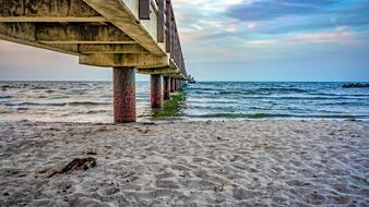Beautiful sea bridge on the pillars, on the beautiful sandy beach of the Baltic Sea