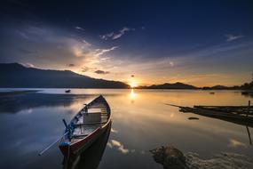 boat on the seashore against the background of dawn