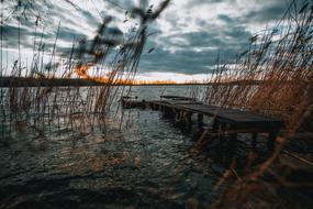 ruined pedestrian wooden bridge on the lake