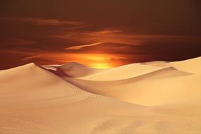 sun over sand dunes at dusk