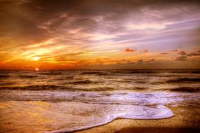 beach with waves on the north sea at sunset