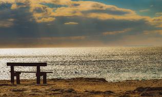 clouds on the horizon and a wooden bench by the sea, cavo greko, cyprus