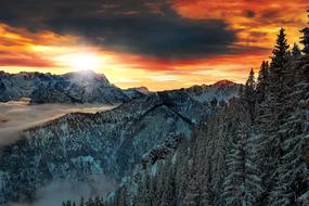 landscape of snowy alpine mountains against the backdrop of a fiery sunset in Upper Bavaria