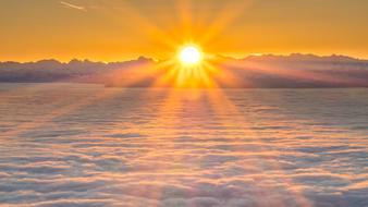 bright sun above the clouds in the alps