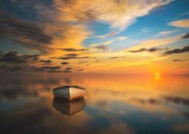 boat on calm water at colorful sunset