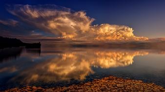 white clouds are mirrored in the sea