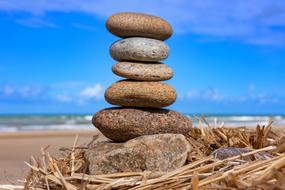 tower of stones on the beach against the blue sky