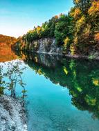 reflection of colorful forest on the rocks on the surface of the lake