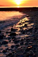 stones on the seashore at sunset