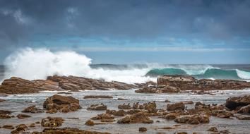 Beautiful, rocky coast of South Africa, with the waves, under the cloudy sky
