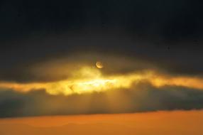 Sunset, sun behind dark clouds
