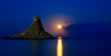 rock in the ocean at dusk