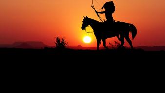 silhouette of an indian on horseback at sunset