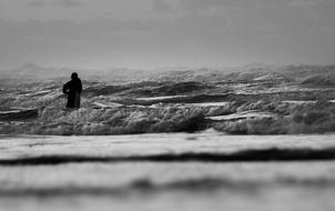 black and white photo of a fisherman in the ocean