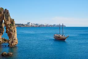 panoramic view of a boat on blue water amidst a picturesque landscape
