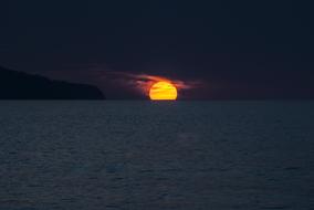 bright setting sun over the ocean in the azores