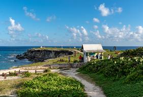 Beautiful and colorful landscape of the Isla Mujeres in Mexico, with the plants on the cliffs, under the blue sky with clouds
