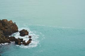fishermen on the rocks by the sea