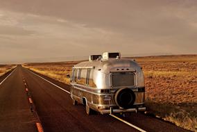 landscape of the vintage camper bus driving on road in wilderness in usa
