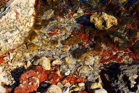 Glinting colorful stones under clear water