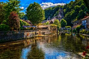 Beautiful landscape of the river, among the colorful plants and mountains in Brantome, France, in summer