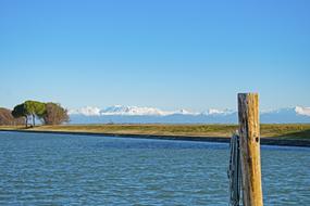 green island on a background of snowy mountains in Italy