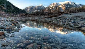 Beautiful lake with the stones and snowy mountains