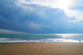 white clouds over the beach near the sea