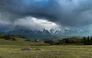 dramatic sky over the peaks of snow-capped mountains