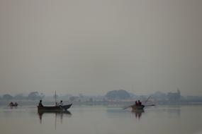 fishing boats on a lake in the fog in Asia