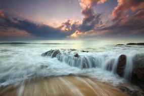 Beautiful, white waves on the ocean, at colorful sunrise