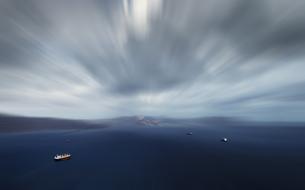 blurry cloudy sky above boats at sea