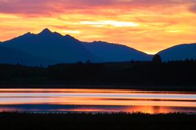 colorful sunset reflected in a mountain lake