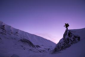 human silhouette on top of snowy rock at purple sunset sky, canada, quÃ©bec
