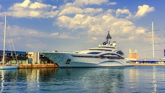 Beautiful white boat in the port, under blue sky with white clouds