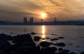 Beautiful landscape with the bridge, from the rocky coast, at colorful sunset