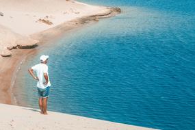 man on a sand dune near the water