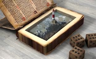 Beautiful lighthouse, among the water in the vintage book and wooden dices