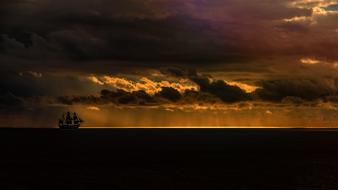 distant Sailing Vessel in Ocean at stormy sunset