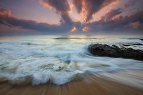 Motion of Waves on sand beach at sunrise