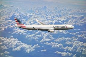 american plane flies above the clouds