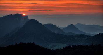 Beautiful landscape of the mountains with trees at colorful sunset in the sky