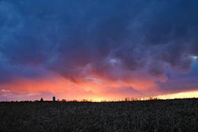 colorful fluffy clouds at sunset sky above earth at dusk