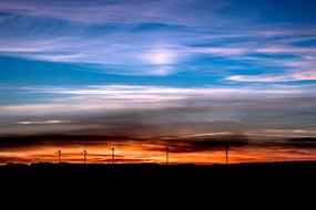 wind power plants against the backdrop of a golden setting sun