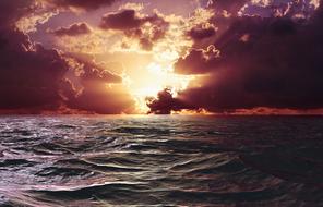 ocean waves against the backdrop of the bright sun and evening sky