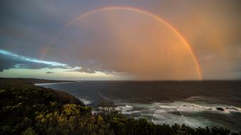 full rainbow in the ocean