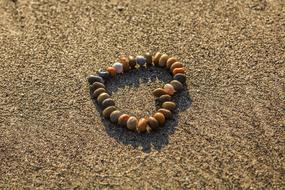 fine pebbles in Heart shape on grey sand