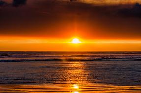 Sun setting at horizon above Ocean